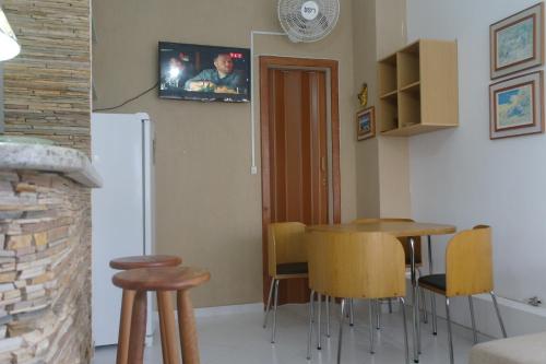a kitchen with a table and chairs and a refrigerator at Apartamento Casa da Praia in Cabo Frio