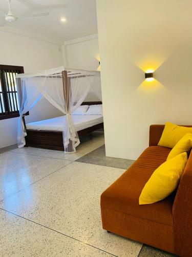 烏納瓦圖納的住宿－Oshi villa，一间卧室配有一张床和一个沙发