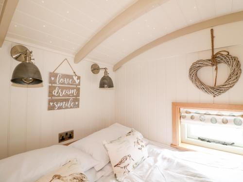 a small bedroom with a bed and a window at Herbie's Shepherds Hut in Nottingham
