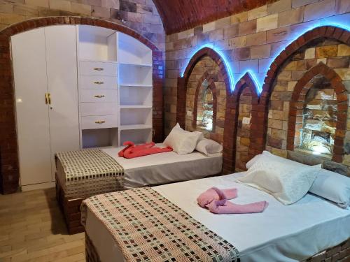 two beds in a room with arches at Laila Flat in Al Aqālitah