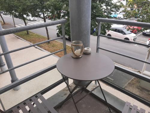 una mesa con una vela en la parte superior de un balcón en Joli studio meublé + parking en sous sol, en La Rochelle
