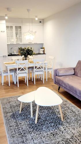 a living room with a couch and a table and chairs at Pinea Apartments in Pobierowo