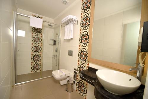 a bathroom with a sink and a toilet and a shower at Exceptional Studio Flat near Hadrian's Gate in Antalya