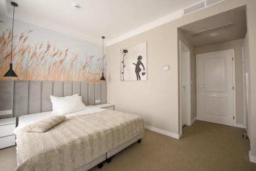 a bedroom with a bed and a painting on the wall at Vila Sarisa in Deva