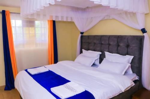een slaapkamer met een groot bed met een baldakijn bij Cool & Calm Home in Homa Bay