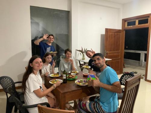 a group of people sitting around a table eating at Plantation Inn in Weligama