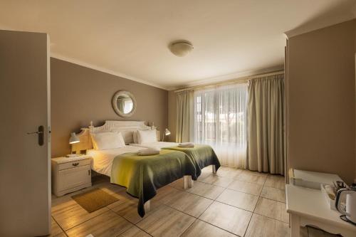 Un dormitorio con una cama grande y una ventana en Guesthouse Fischreiher B&B en Swakopmund