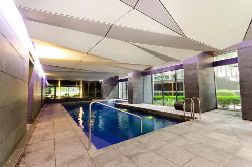 a swimming pool in the middle of a building at 2BR CBD pad, city views, free parking, pool, gym in Melbourne