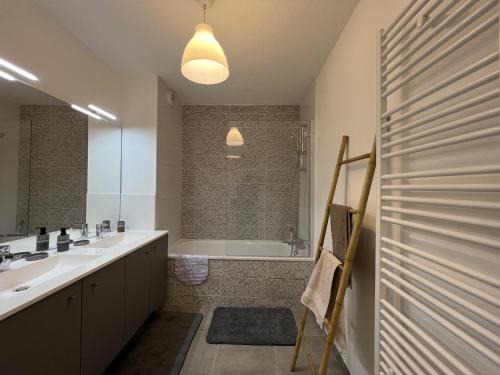 La salle de bains est pourvue d'une baignoire, d'un lavabo et d'une douche. dans l'établissement Le Cartoucherie - 4p - Parking - Tram & Zénith, à Toulouse