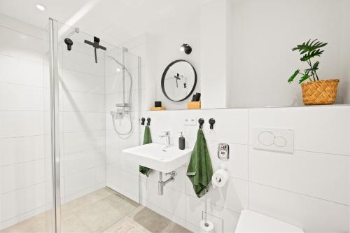 a white bathroom with a sink and a shower at Sali Homes - Mozart EINS in Bietigheim-Bissingen