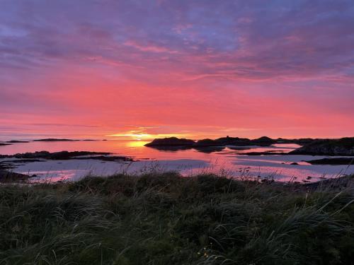 a sunset over a body of water with the sun setting at Apartment Utsikten in Andenes