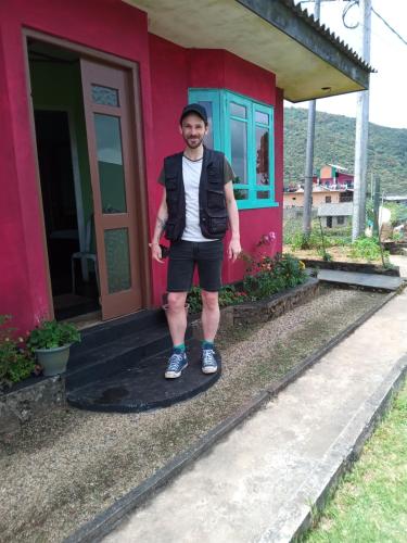 a man standing in front of a house at Mount View Cottage in Nuwara Eliya