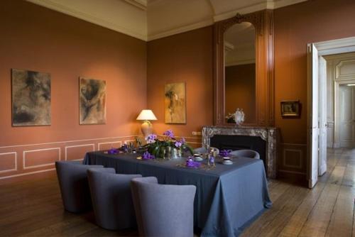 a dining room with a table with purple flowers on it at Château de Vierset in Vierset-Barse