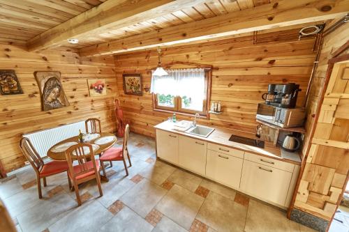 a kitchen and dining room with a table in a log cabin at Domek Eva - Polanica Zdrój centrum in Polanica-Zdrój