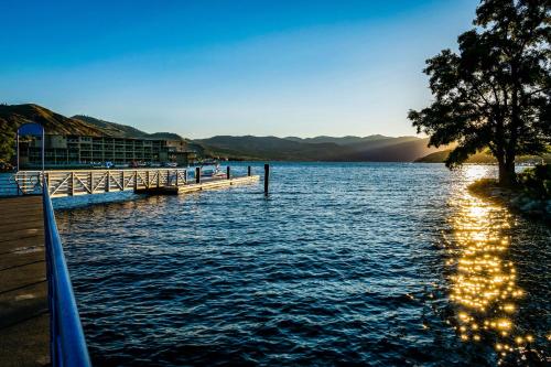 a body of water with a pier and a tree at Chelan Resort Suites Coco Chelan 212 in Chelan