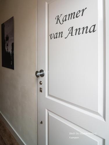 a white door with the words korman ran amuna on it at De Stadsboerderij in Kampen
