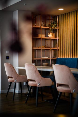 a room with two chairs and a table and a book shelf at Vila Sarisa in Deva