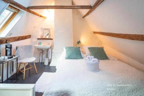 a bedroom with a white bed and a sink at De Stadsboerderij in Kampen