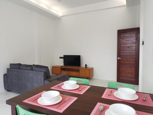 - un salon avec une table et un canapé dans l'établissement Nanyang Homestay 3 rooms 10 pax- Ground Floor, à Sibu