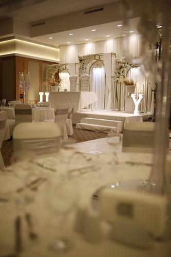 duży pokój z białymi stołami i krzesłami w obiekcie Tugcan Hotel w mieście Gaziantep