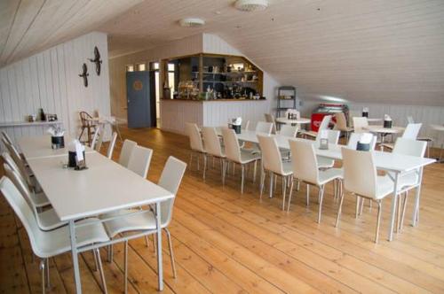 a dining room with white tables and white chairs at Skärgårdsbyn S:t Anna in Mon