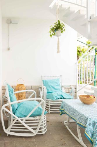 a porch with two chairs and a table and a swing at VITEDIMARE APARTMENT SABBIA - SAND in Muggia