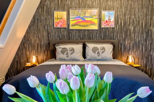 a bedroom with a bed with pink tulips at Liv Inn in Hillegom