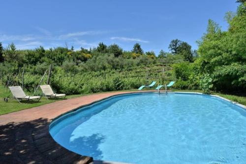- une piscine avec 2 chaises dans l'établissement Molino in chianti, à Mercatale Val Di Pesa