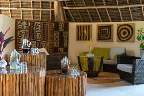 a living room with two tables with vases on them at Essque Zalu Zanzibar in Nungwi