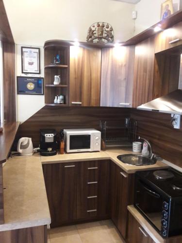 a small kitchen with a microwave and a sink at Advel Guest House in Madzhare