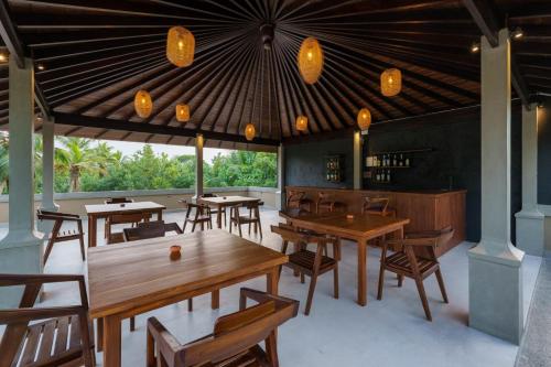 a restaurant with wooden tables and chairs and lights at Kiss Blossom in Mirissa