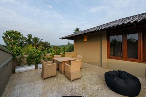 a patio with a table and chairs on a balcony at Kiss Blossom in Mirissa