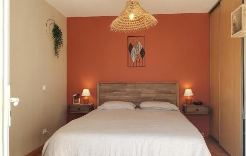 a bedroom with a large bed with an orange wall at 4 Bedroom Beautiful Home In Goult in Goult