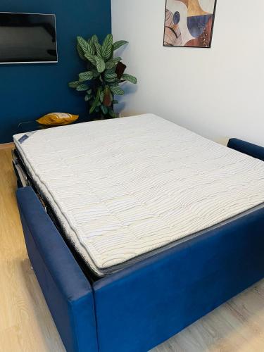 un matelas assis au-dessus d'un lit bleu dans l'établissement Cosy Apartement near Geneva, à Saint-Julien-en-Genevois
