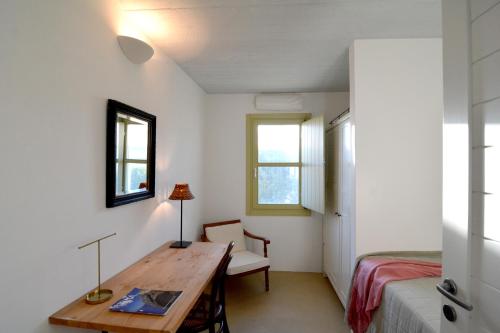 a room with a desk and a bed and a table at Cycladic Fos - Entire SeaView 2BR Villa by TinosHost in Triandáros