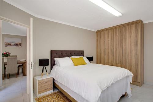The Cycad. 4-Bed Home next to Clearwater Mall في روديبورت: غرفة نوم بسرير ابيض ومخدة صفراء