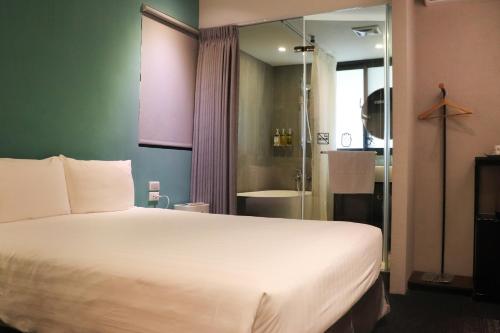 a bedroom with a large bed and a bathroom at Cho Hotel 3 in Taipei