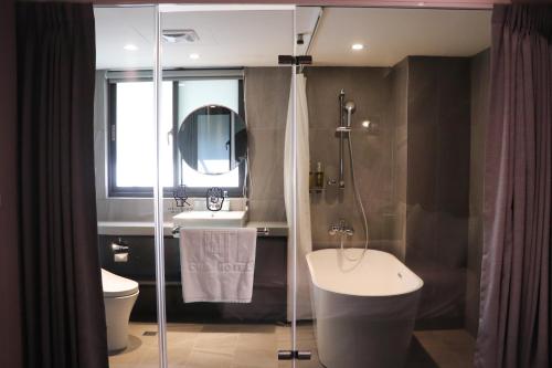 a bathroom with a shower and a sink and a toilet at Cho Hotel 3 in Taipei