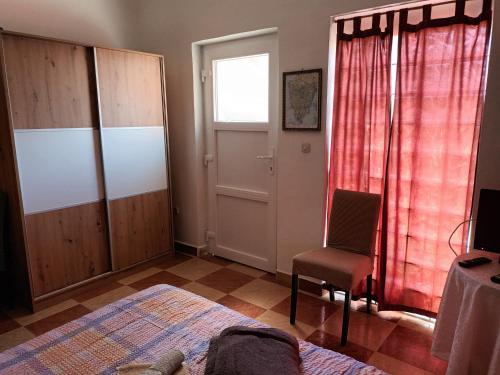 a bedroom with a bed and a chair and a window at Apartment Mirjana I in Šišan