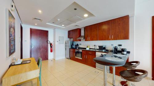 eine Küche mit Holzschränken und einer Arbeitsplatte in der Unterkunft LV38 - Elegant 2BHK in Lake View Tower in Dubai