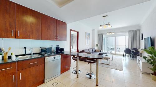 eine Küche mit Holzschränken und ein Wohnzimmer in der Unterkunft LV38 - Elegant 2BHK in Lake View Tower in Dubai
