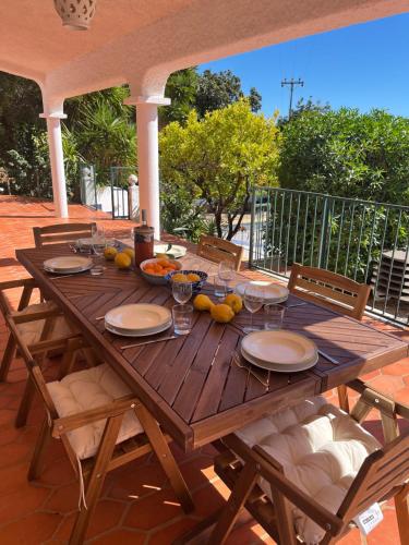 un tavolo in legno con piatti e bicchieri su un patio di Beautiful private Villa with pool, Boliqueime, Loulé a Boliqueime