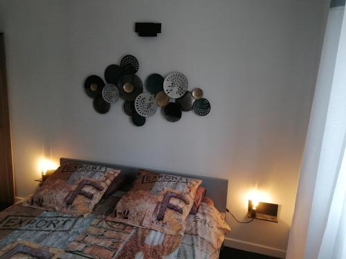 a bedroom with a bed with clocks on the wall at VILLA TERRE NEUVE in Signes