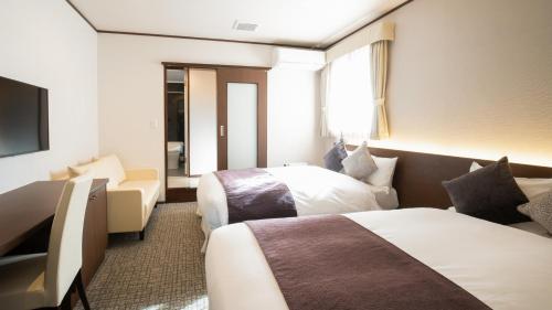 Habitación de hotel con 2 camas y TV en HOTORI no HOTEL BAN en Fujikawaguchiko