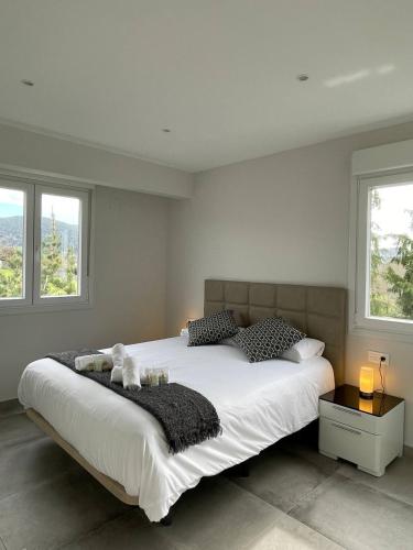 1 cama blanca grande en un dormitorio con ventanas en Gure Urdaibai by Urdaibai Rentals, en Altamira