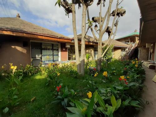 a garden in front of a house with flowers at Lodge Du Chateau in Gonder