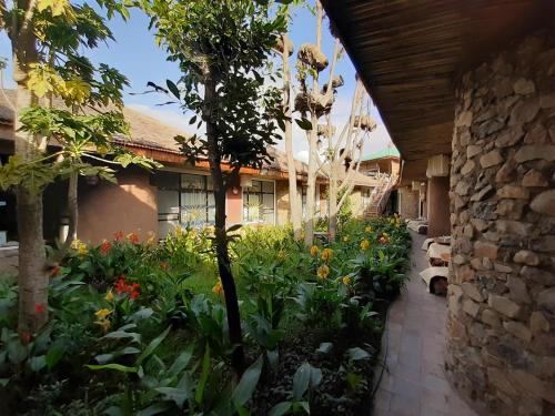 a garden in front of a building with flowers at Lodge Du Chateau in Gonder