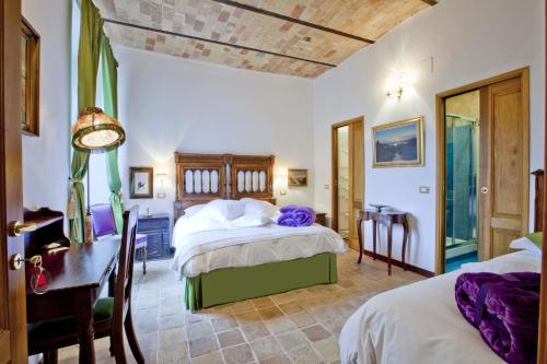 um quarto com 2 camas e uma secretária. em B&B Il Marchese Del Grillo em Sulmona