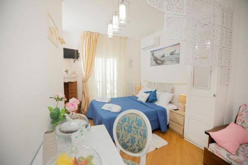 een kleine slaapkamer met een blauw bed en een tafel bij Io, te e il mare in Polignano a Mare