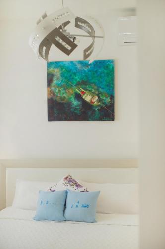 a bedroom with a bed with a painting on the wall at Io, te e il mare in Polignano a Mare